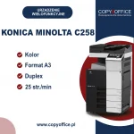 Reklama urządzenia wielofunkcyjnego Konica Minolta C258. Urządzenie jest czarno-białe z panelem dotykowym na górze. Reklama podkreśla kluczowe cechy: drukowanie w kolorze, format A3, drukowanie dwustronne i prędkość 25 stron na minutę. Znajduje się również logo firmy "Copy Office" z hasłem "Rozwiązania dla dokumentów" oraz strona internetowa www.copyoffice.pl.